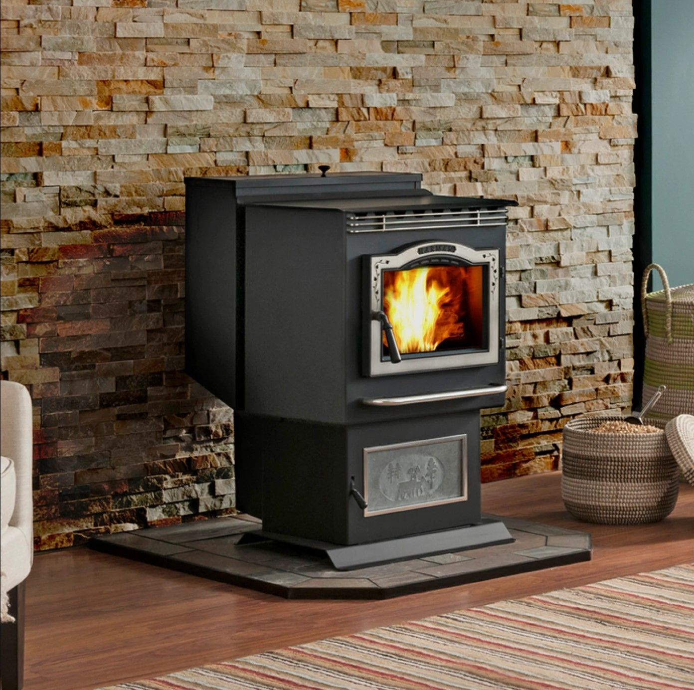 Black pellet stove with a roaring fire in a room with a brick wall and wooden floor.