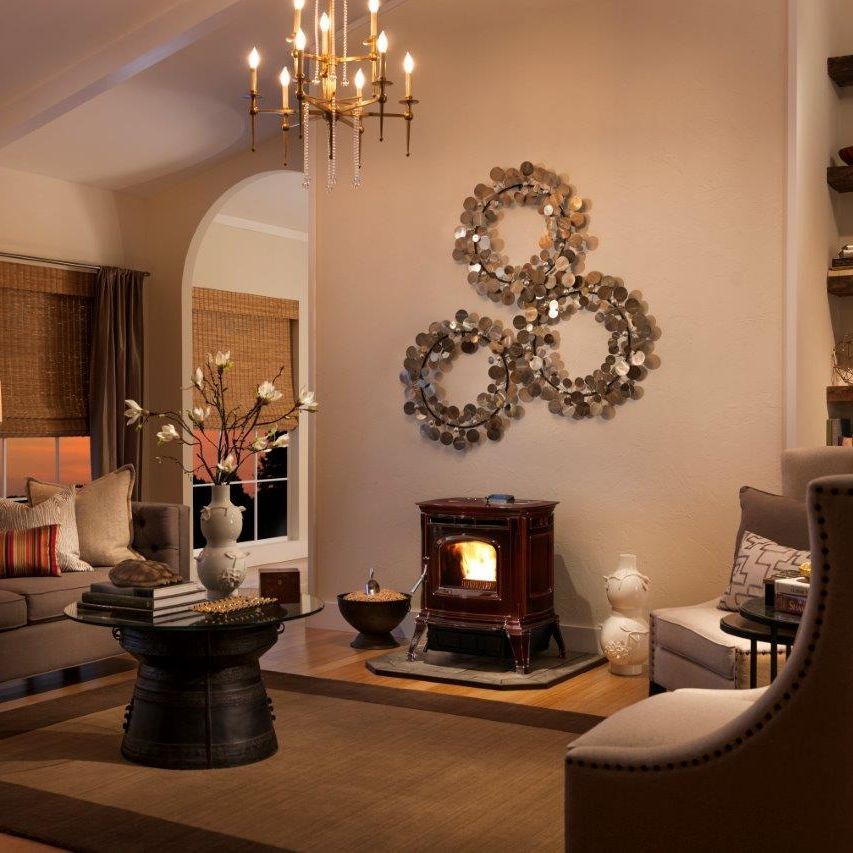 Cozy living room with a decorative fireplace, three circular metal wall hangings, and a chandelier.