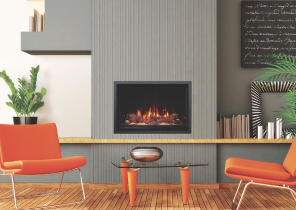 A modern living room with a fireplace, orange chairs, and a glass coffee table; the wall is gray with wood paneling.
