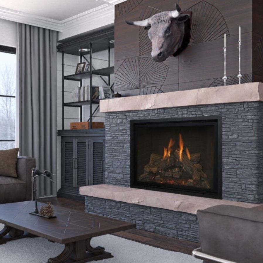 Living room with a fireplace, a bull head decoration above it, and dark gray stonework. A bookshelf and coffee table are also visible.
