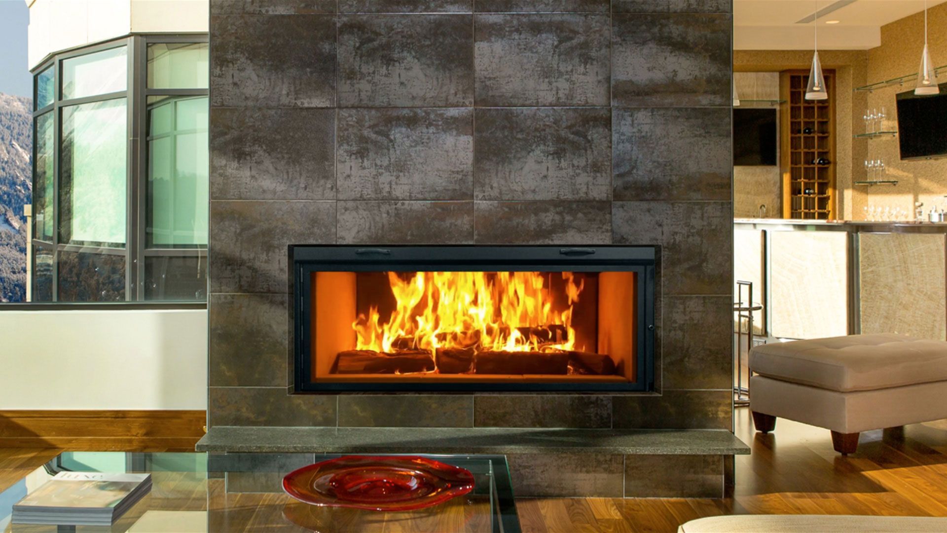 A fireplace with a stone facade and Christmas decorations, including lit candles, garland, and bows. The fire is burning.