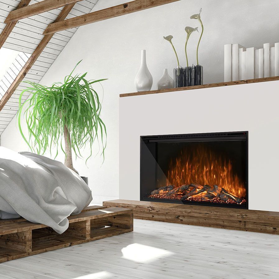 Bedroom with an electric fireplace built into a white wall. A wooden bed frame and shelf with décor are visible.