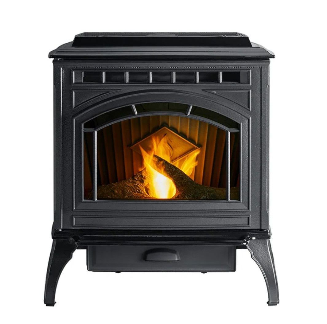 Black cast iron stove with a burning fire visible through the glass front, a drawer below.