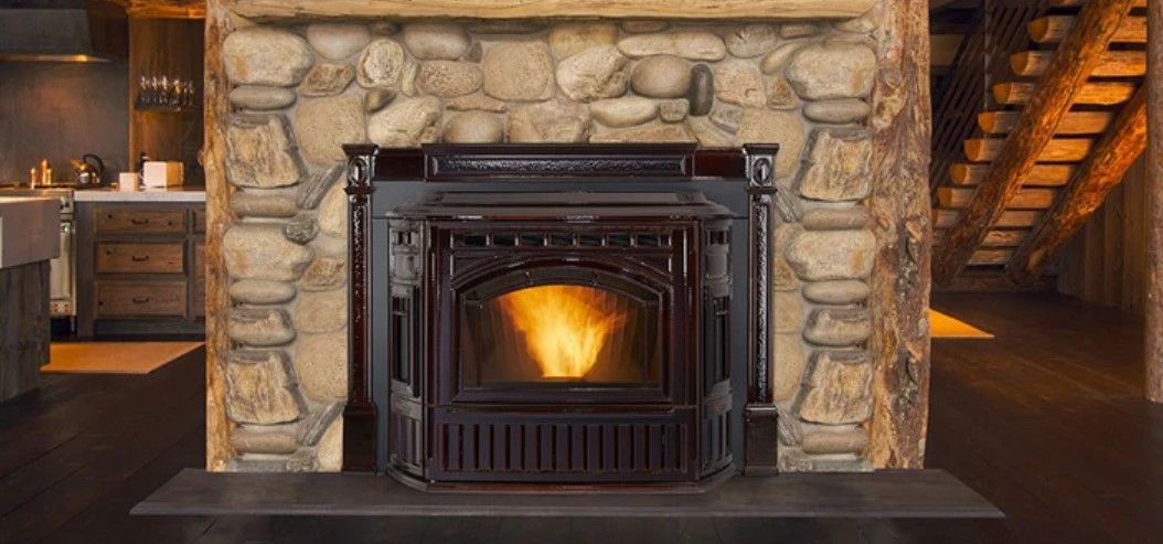 A lit fireplace set in a rustic stone hearth. A staircase and kitchen are visible in the background.
