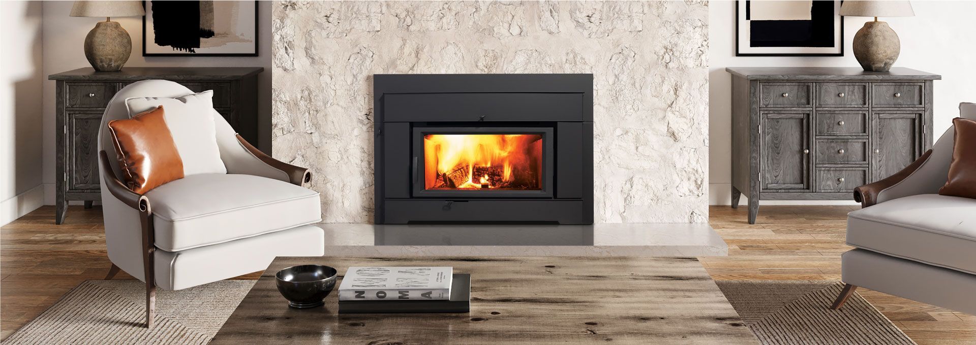 Cozy living room with a fireplace, chairs, and a coffee table. Warm fire glows within the dark frame of the fireplace.