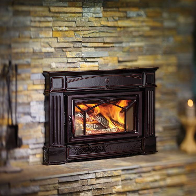 Dark brown electric fireplace against a stone wall, with simulated flames visible through glass.