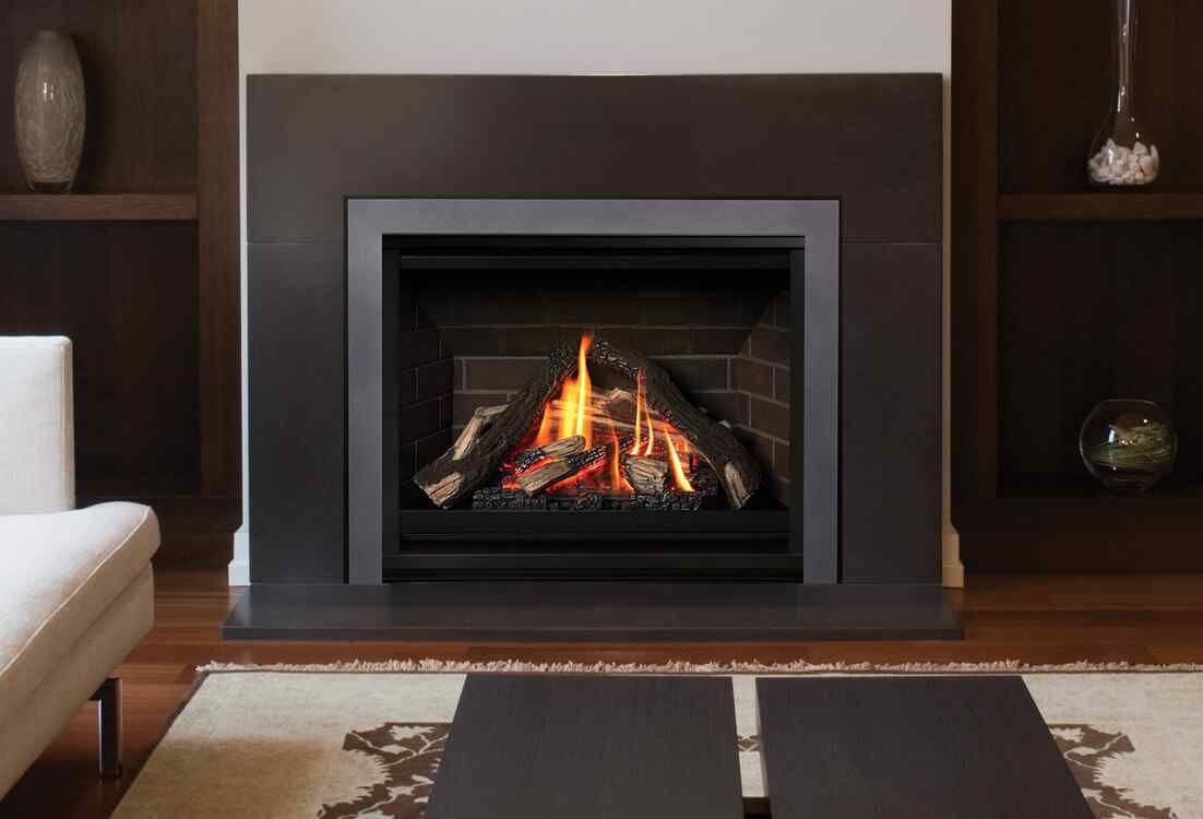 A modern fireplace with burning logs, framed in dark wood, set in a living room with built-in shelves.
