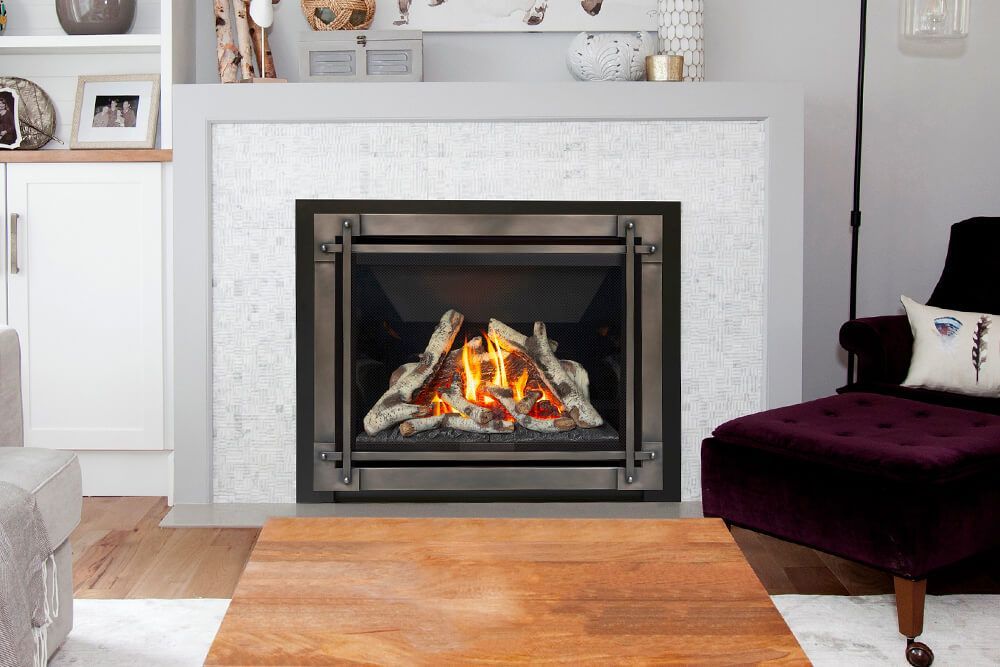 Fireplace with a lit flame in a living room setting. It features marble surround, a dark metal frame, and a nearby purple ottoman.