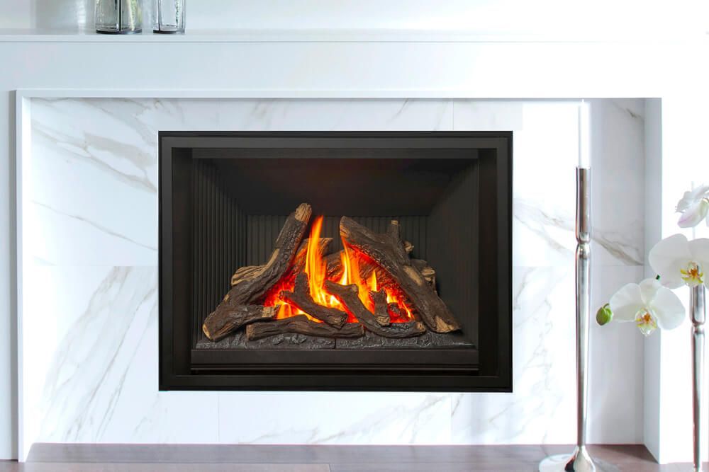 Gas fireplace with faux logs and flames, set in a marble surround.