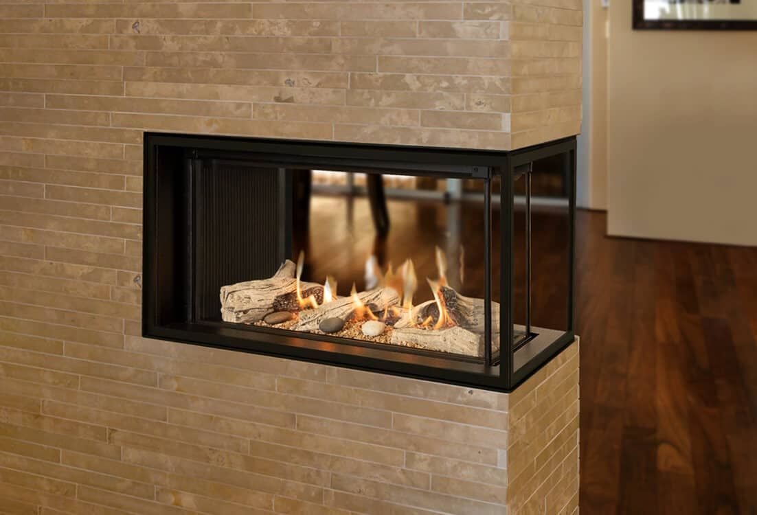 A modern corner fireplace with burning logs, framed by a black metal casing and set into a beige stone wall.
