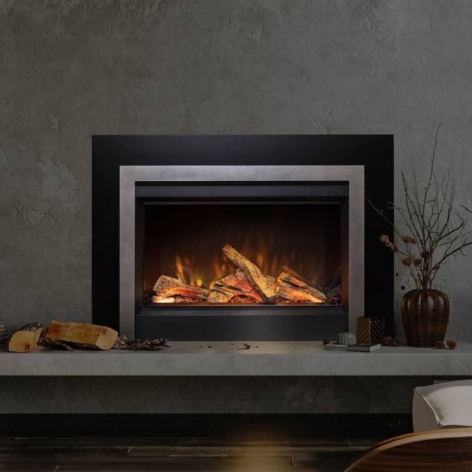 Electric fireplace with a black and silver frame against a gray wall, with faux logs and flickering flames.