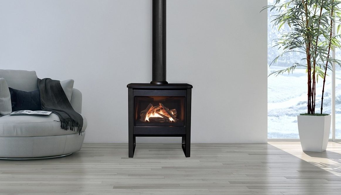 A black fireplace with a lit fire stands in a modern living room setting, near a white plant pot and a round sofa.