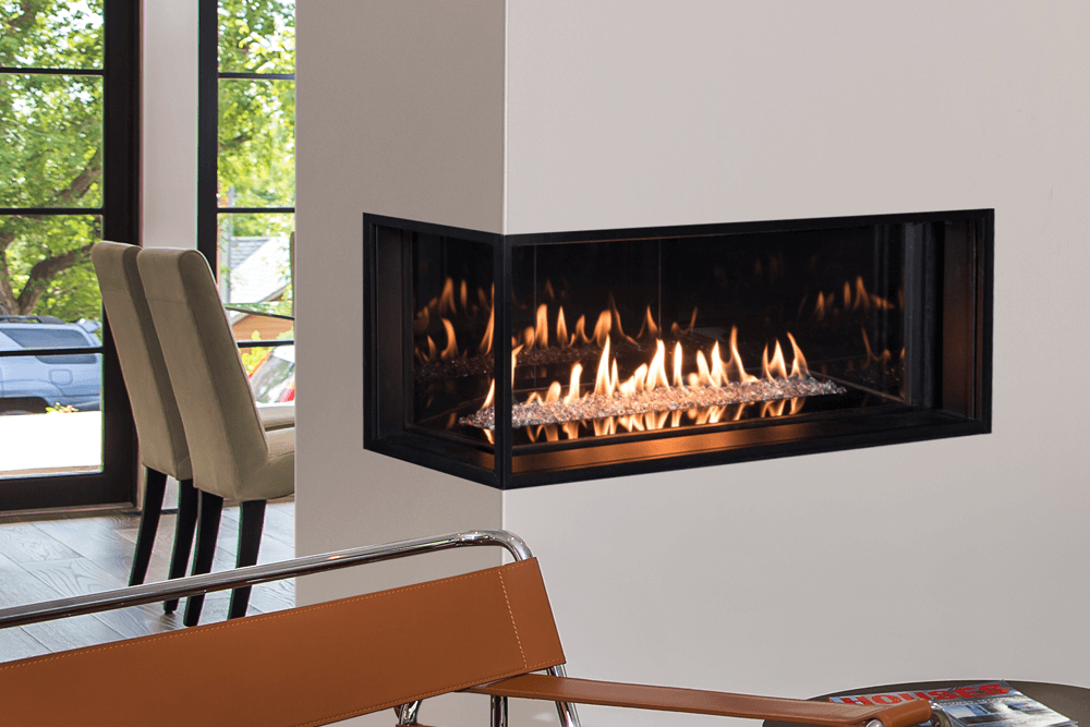 A modern corner fireplace with flames, framed by a black metal casing, against a white wall. A chair sits nearby.