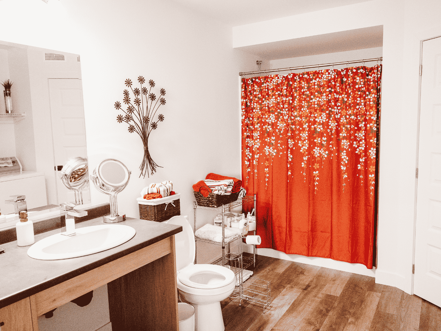 Une salle de bain avec un rideau de douche rouge, un lavabo, des toilettes et un miroir.