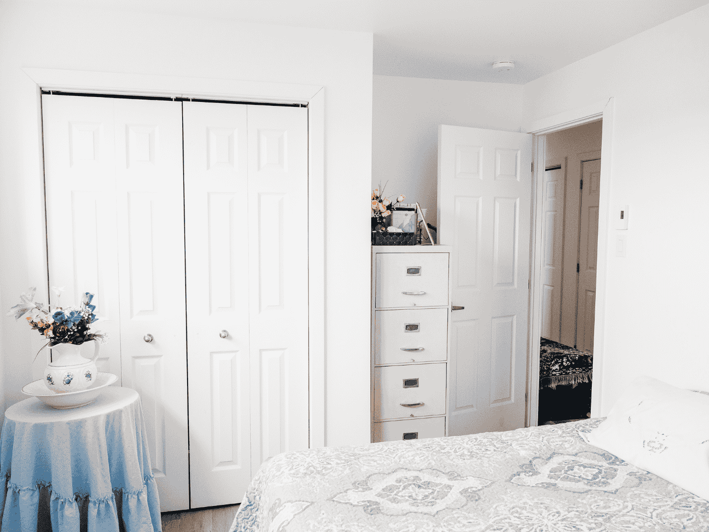 Une chambre avec un lit, une commode et un placard.