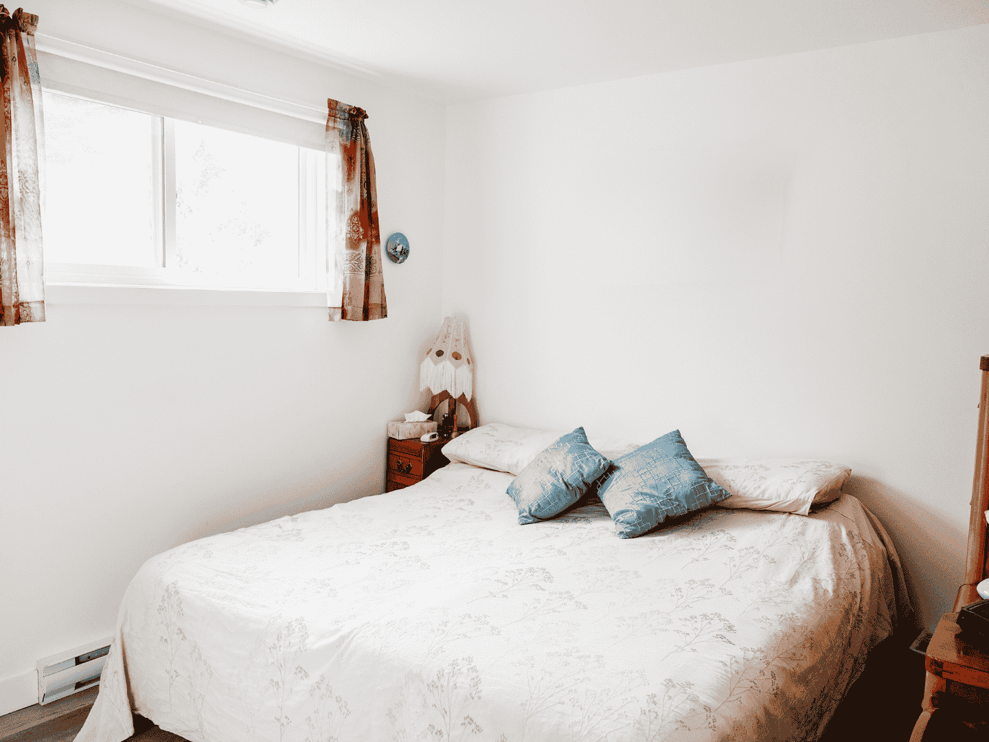 Une chambre avec un lit, une table de chevet et une fenêtre.