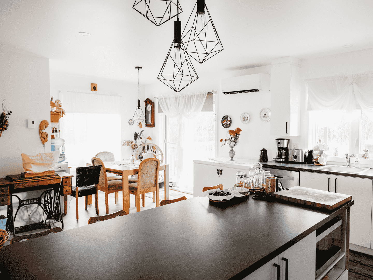 Une cuisine avec un grand îlot au milieu et une salle à manger en arrière-plan.