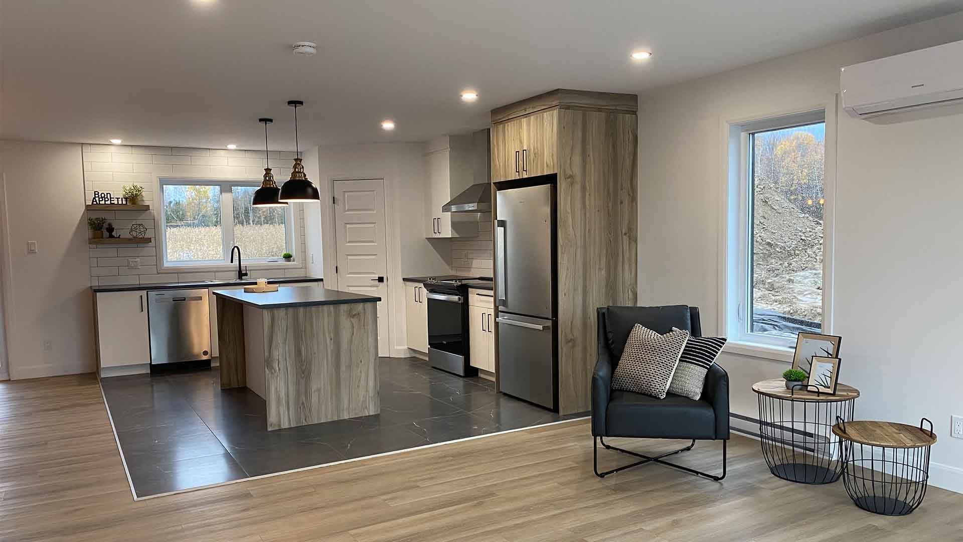 Un salon rempli de meubles et une cuisine avec un grand îlot.