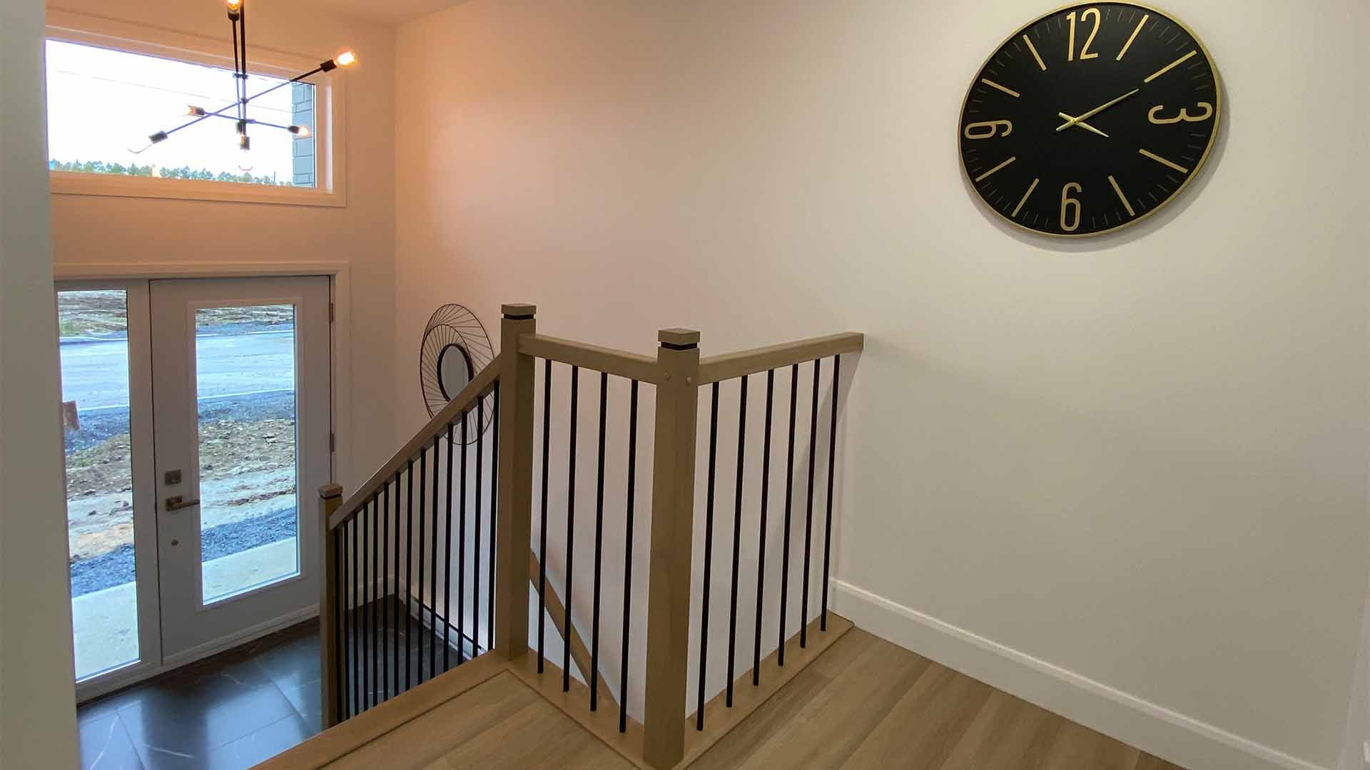 Il y a une horloge sur le mur au dessus des escaliers.
