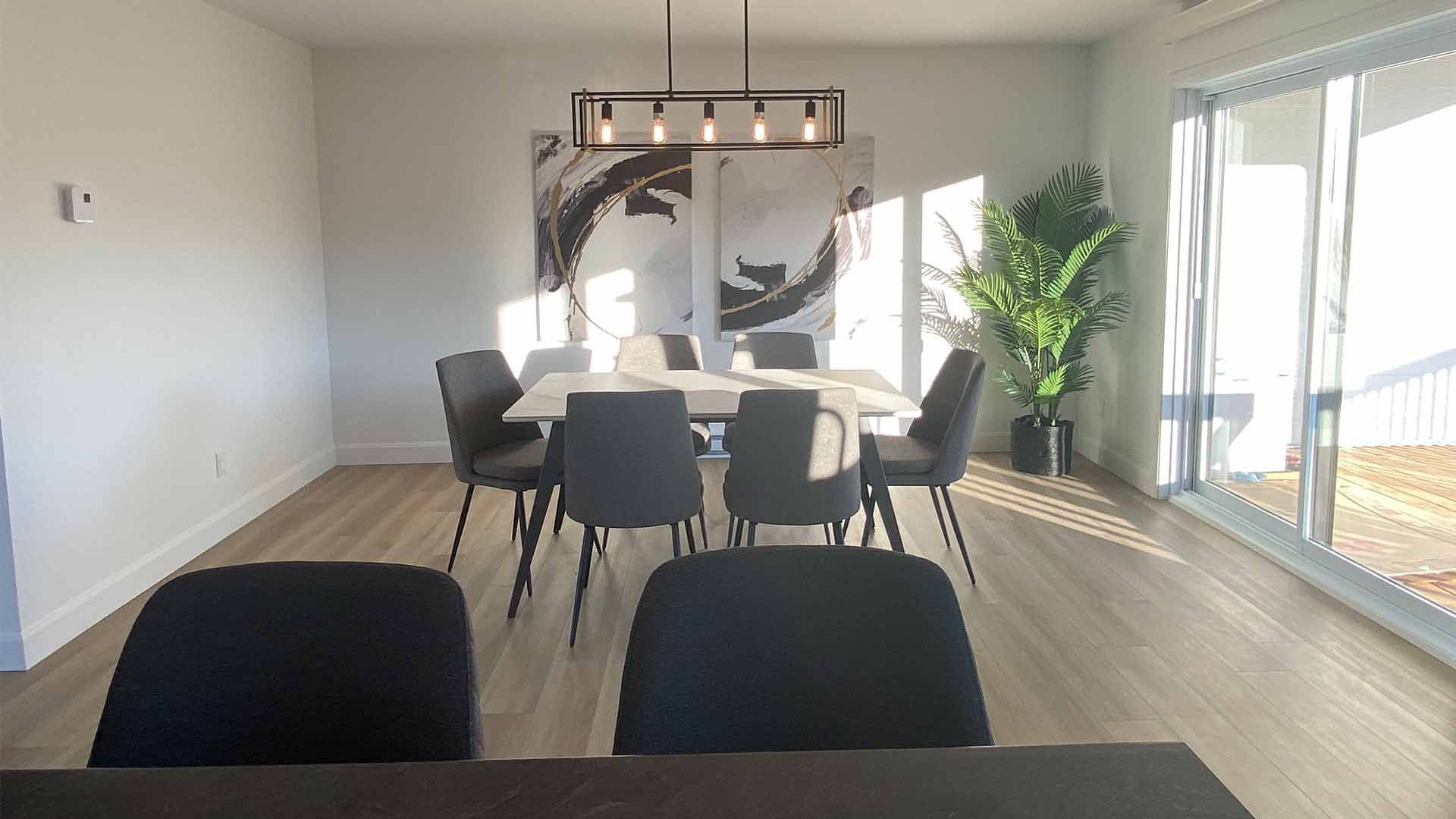 Une salle à manger avec une table et des chaises et une grande fenêtre.