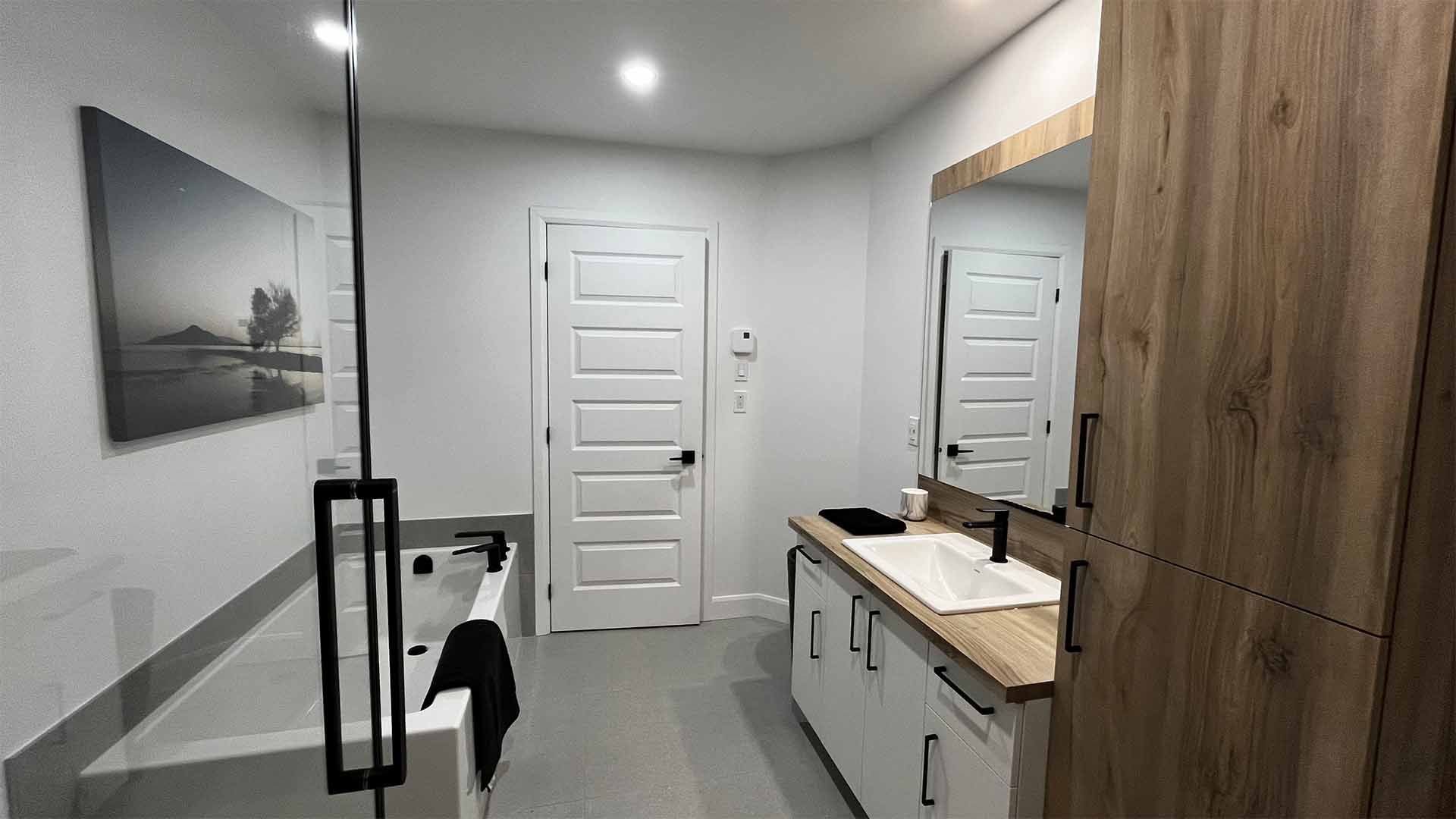 Une salle de bain avec baignoire, lavabo et miroir.
