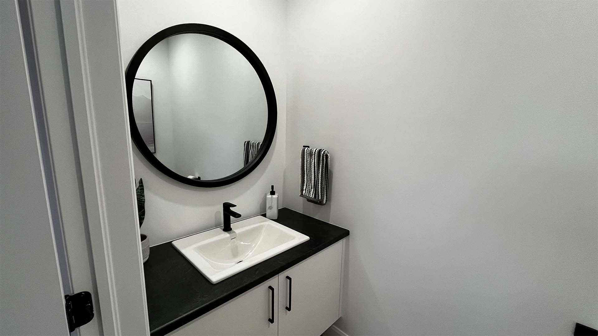 Une salle de bain avec un lavabo et un miroir rond