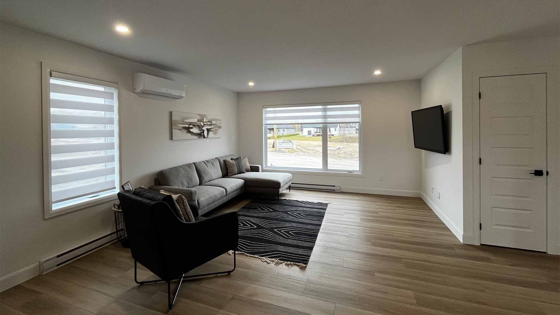Un salon avec un canapé, une chaise et une télévision.