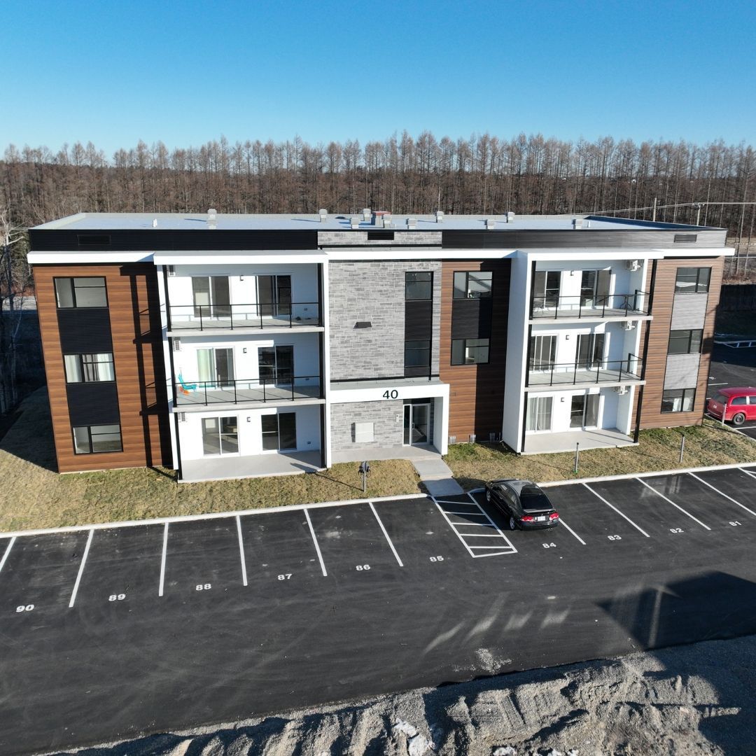 Un grand immeuble d'appartements avec un parking devant