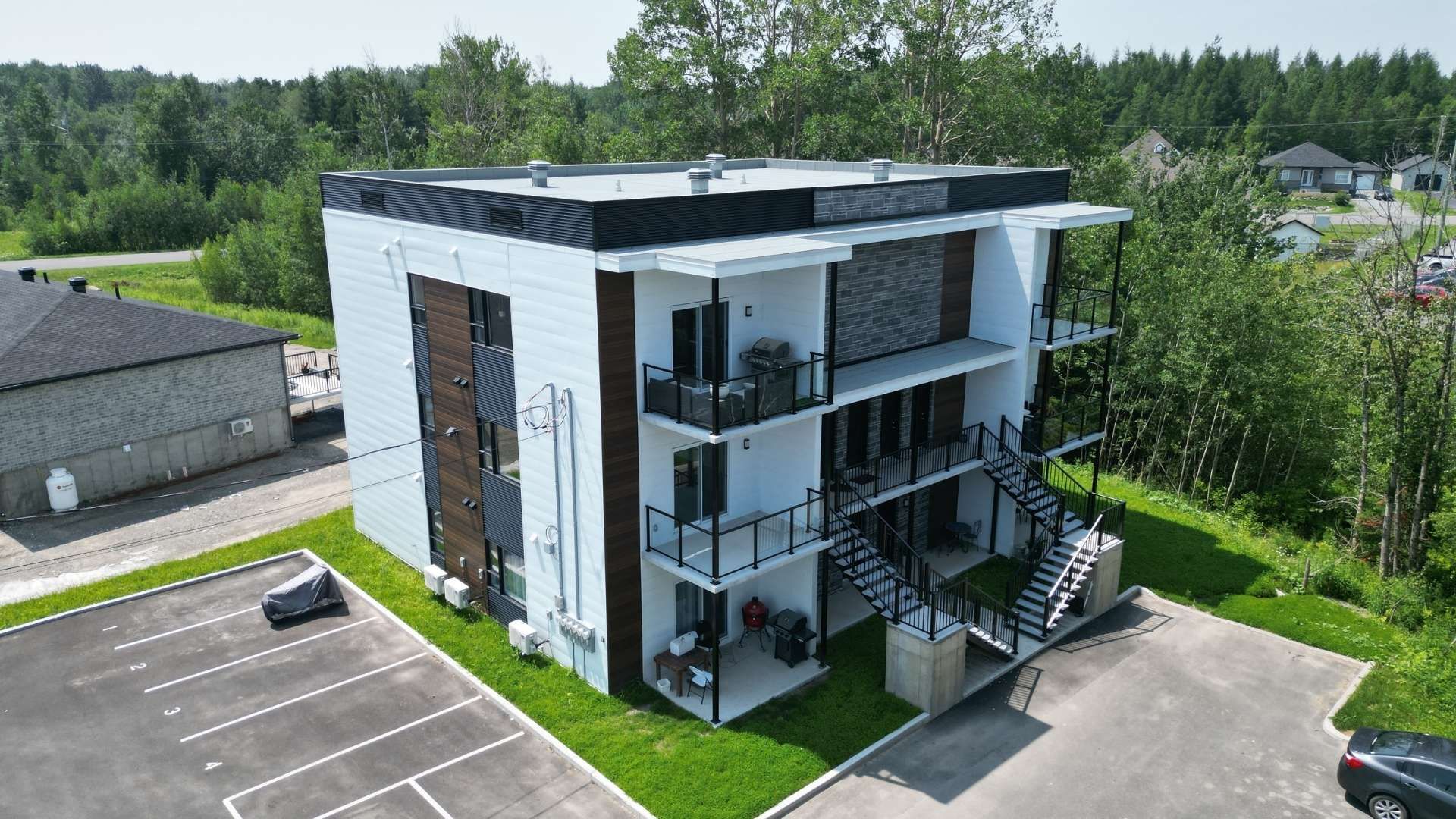 Une impression d'artiste d'un grand immeuble d'appartements avec balcons et escaliers.