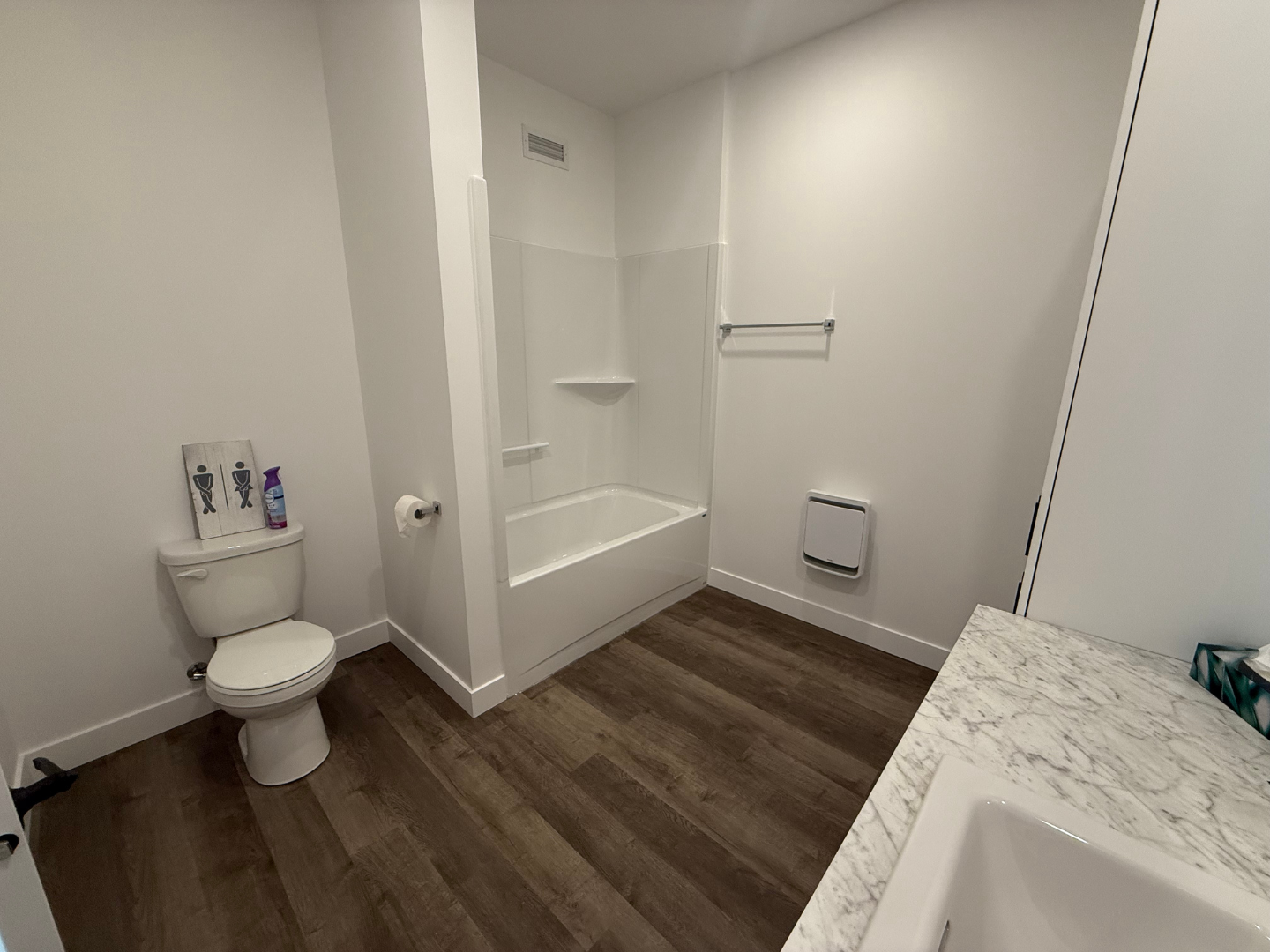 Une salle de bain avec WC, lavabo et baignoire.