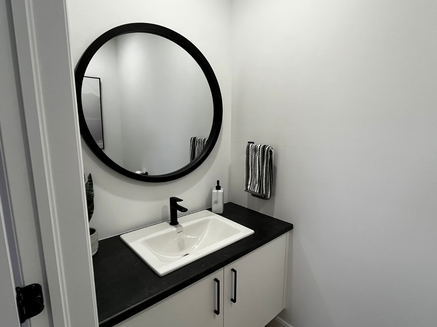 Une salle de bain avec un lavabo, un miroir et des armoires.