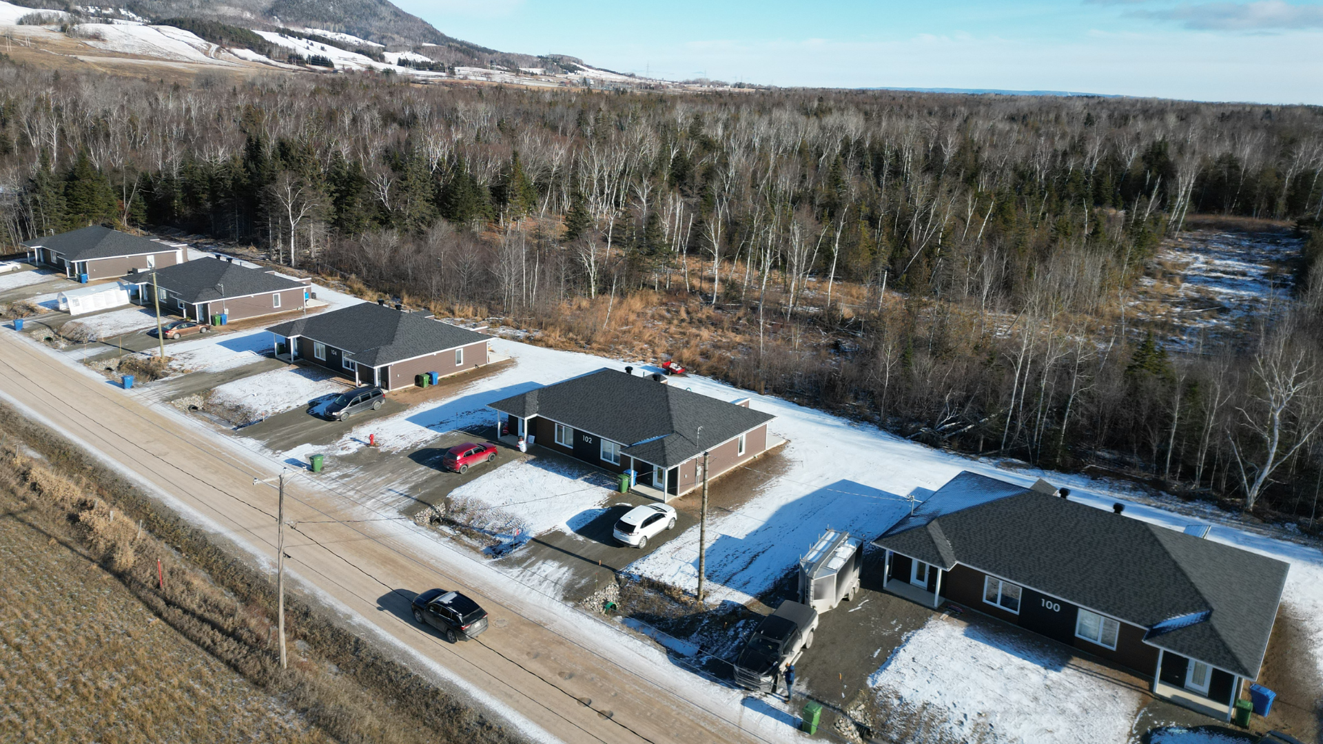 Une vue aérienne d'une rangée de maisons sur une colline enneigée.