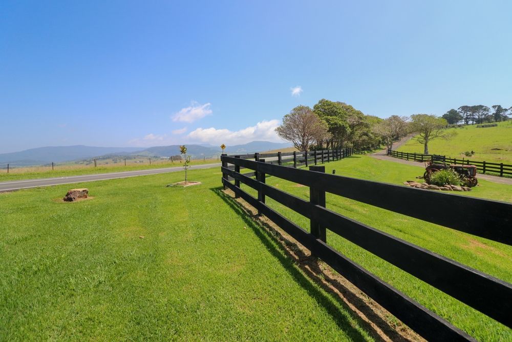 A Black Wooden Fence Surrounds A Lush Green Field — Ridgeline Building Co In Gerringong & Gerroa, NSW