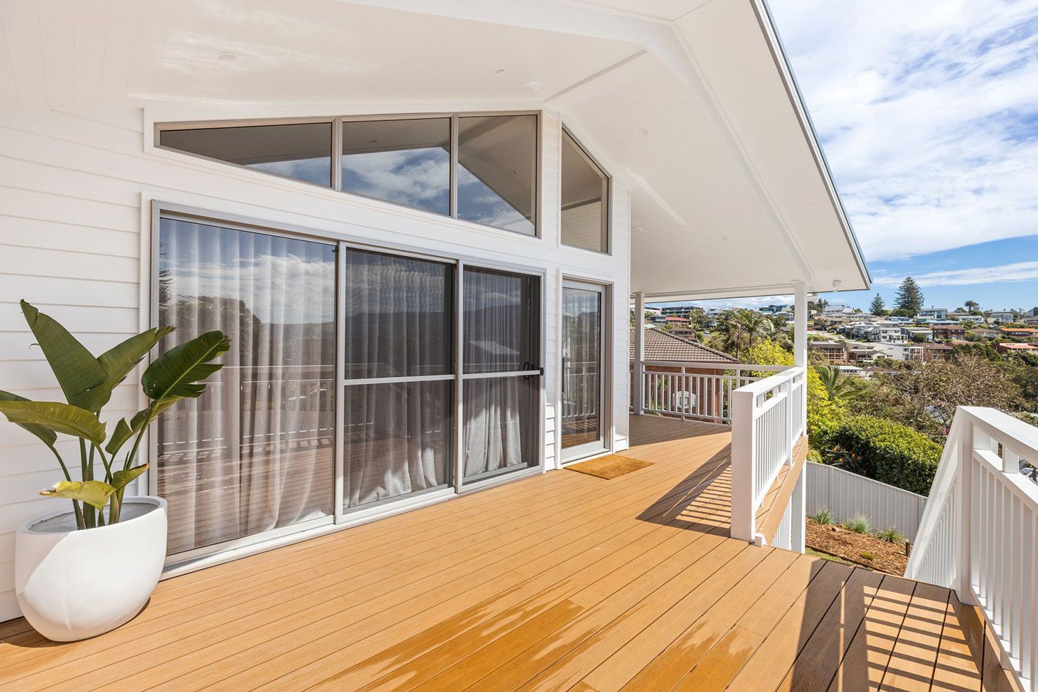 Home Renovation Featuring A Wooden Deck And White Railing