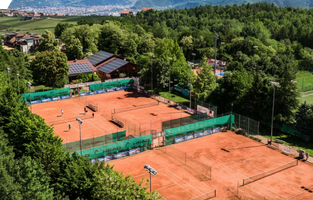 An aerial view of a tennis court surrounded by trees