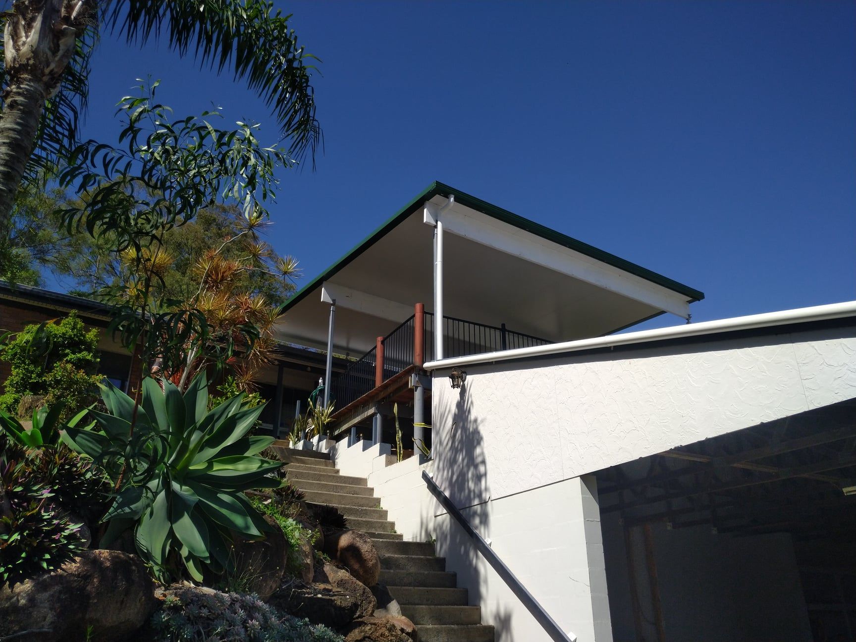 A Large Empty Room With a Wooden Floor and Sliding Glass Doors — Bob Ryan's Home Improvements & Construction Pty Ltd in Beecher, QLD
