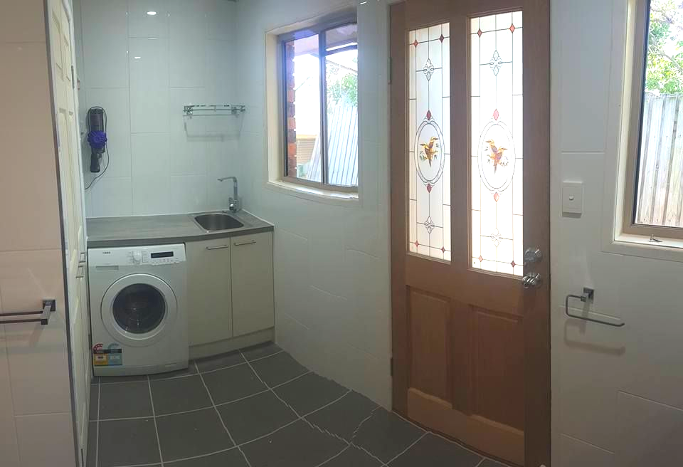 A Laundry Room With a Washing Machine, Sink, and Door — Bob Ryan's Home Improvements & Construction Pty Ltd in Beecher, QLD