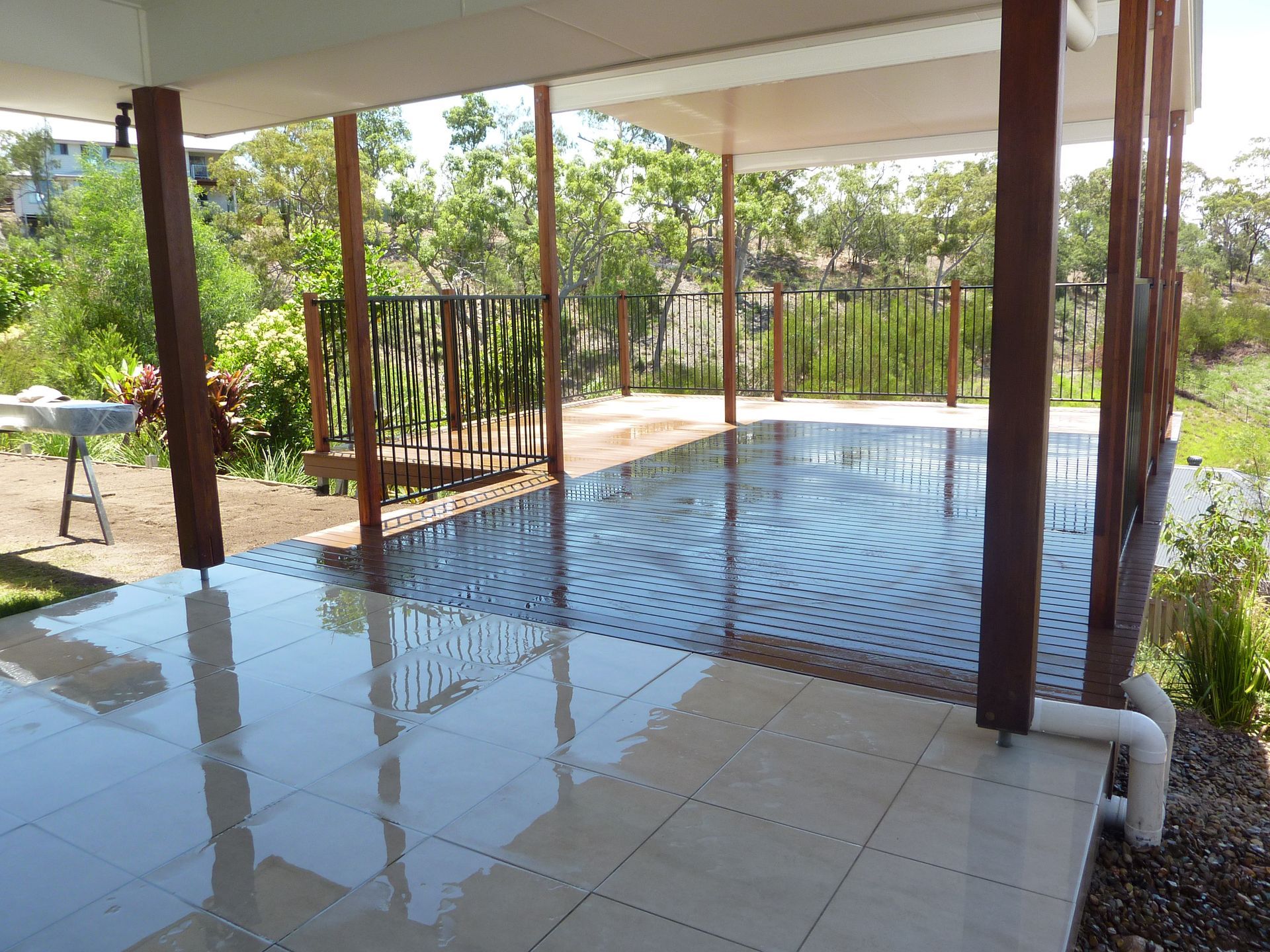 Covered patio with glossy, tiled floor and wooden supports; overlooking greenery — Bob Ryan's Home Improvements & Construction Pty Ltd in Beecher, QLD