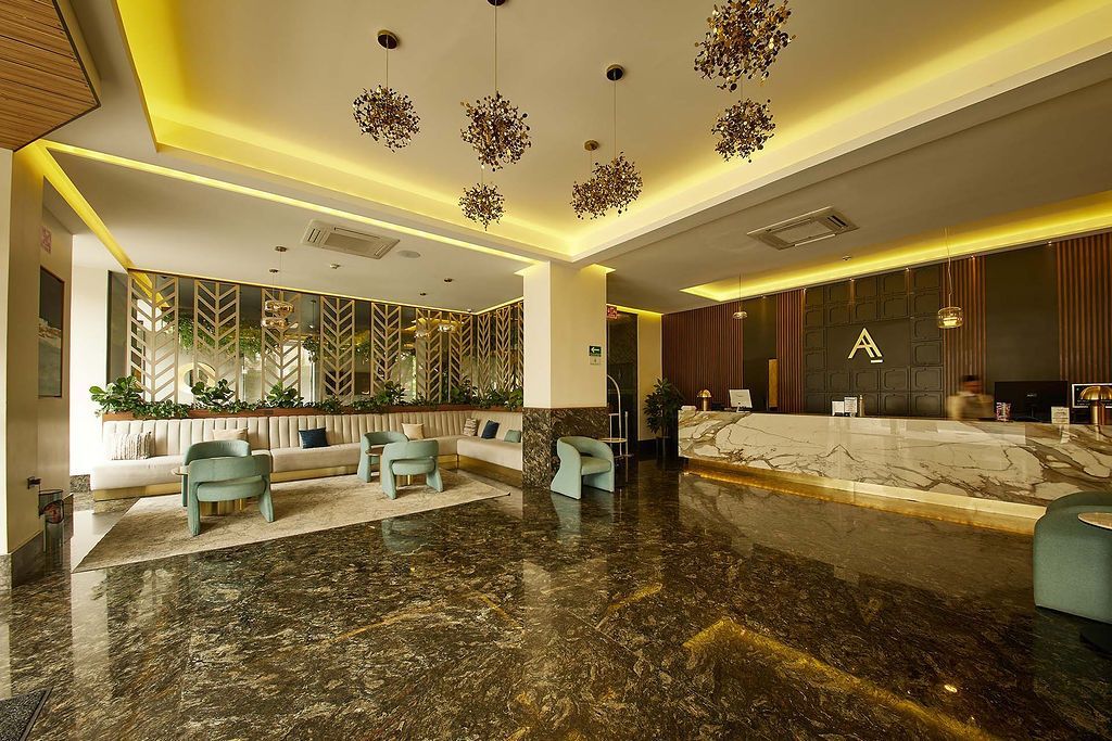 Interior elegante del restaurante con mesas redondas de madera, sillas naranjas y verdes y decoración de pared con espejos.