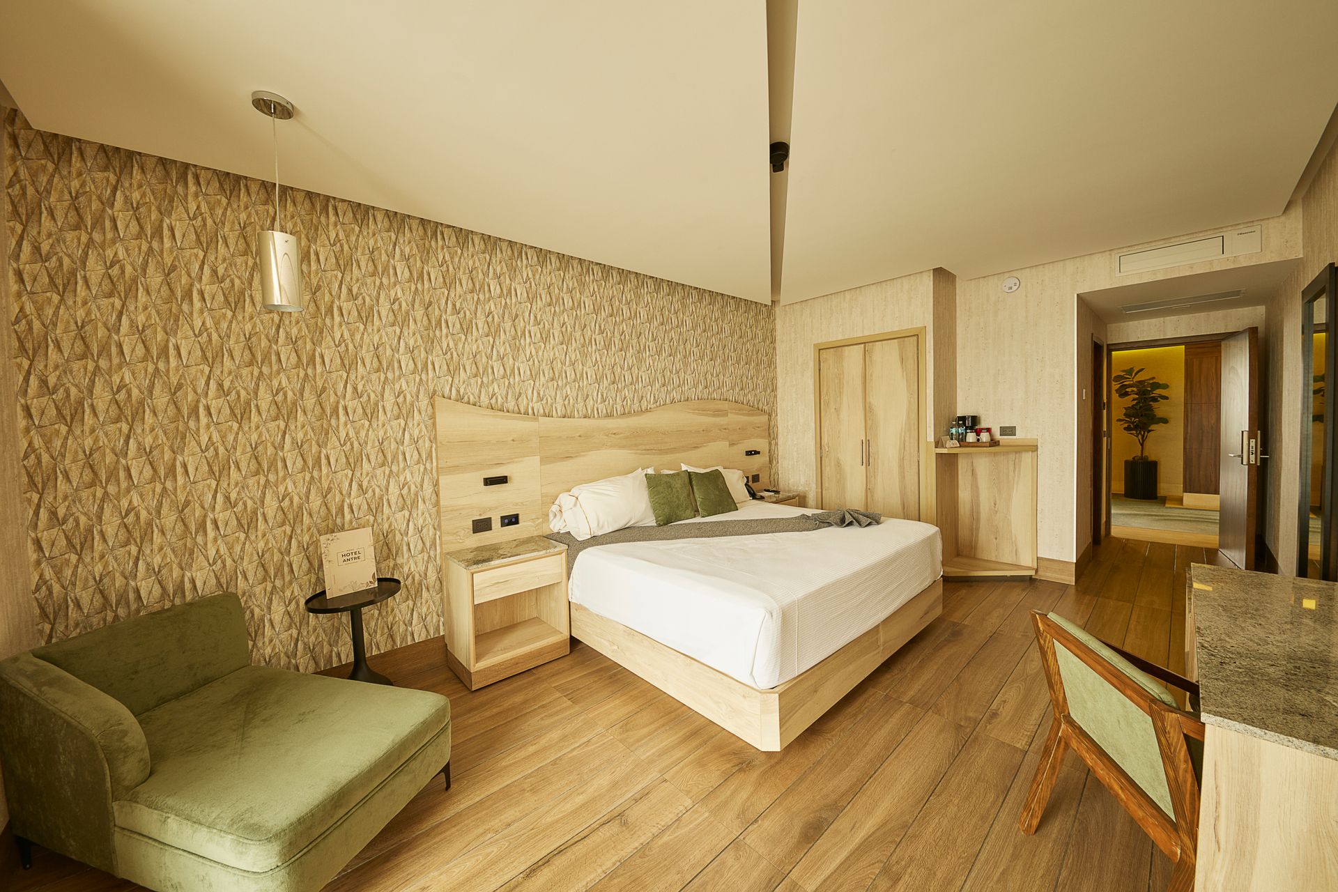 Dormitorio moderno con una cama bien hecha, decoración neutra e iluminación ambiental suave en la pared.