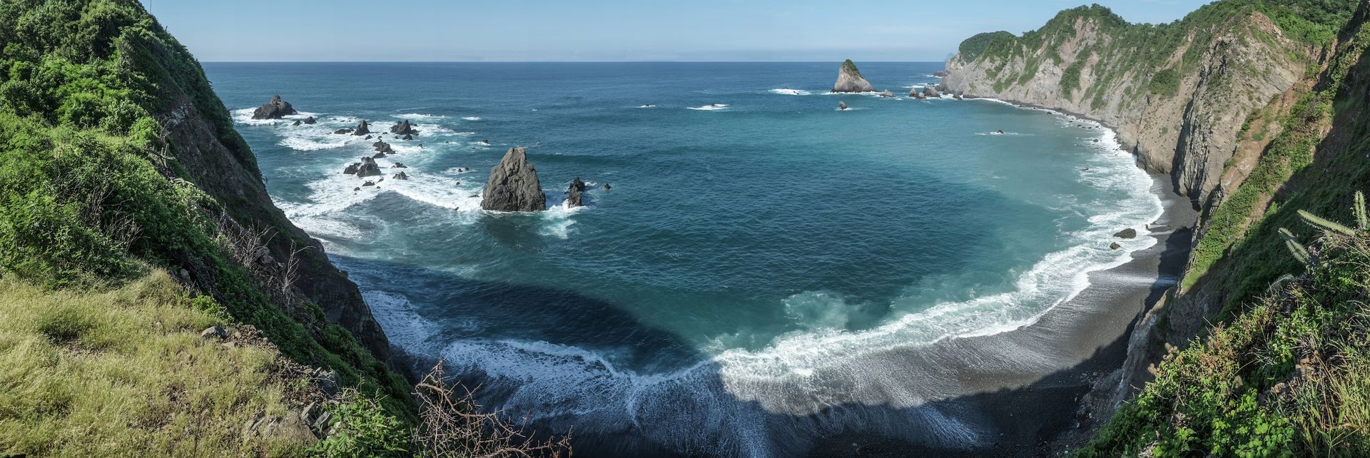 A large body of water surrounded by cliffs and trees.