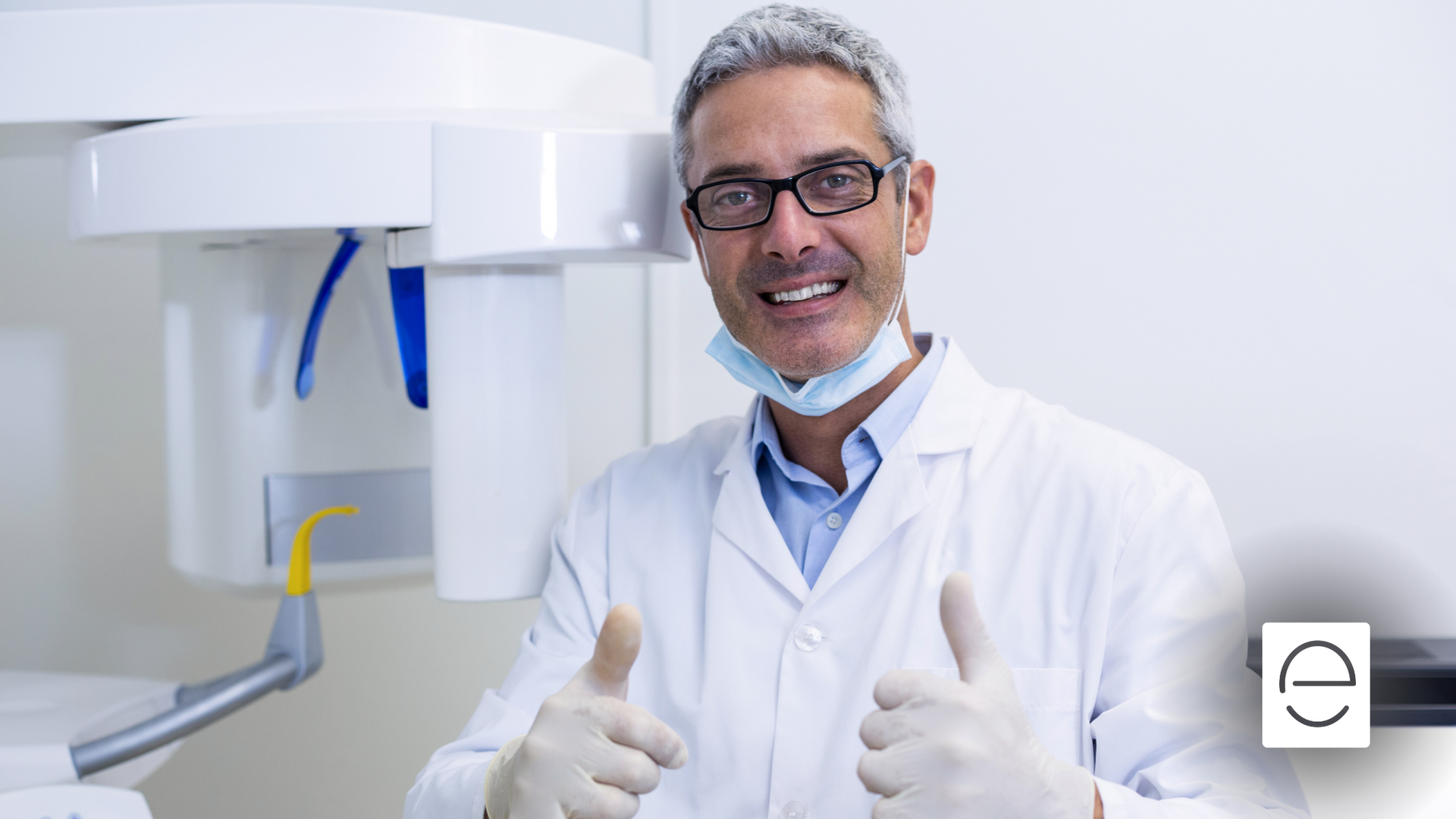 A dentist is giving a thumbs up in a dental office.