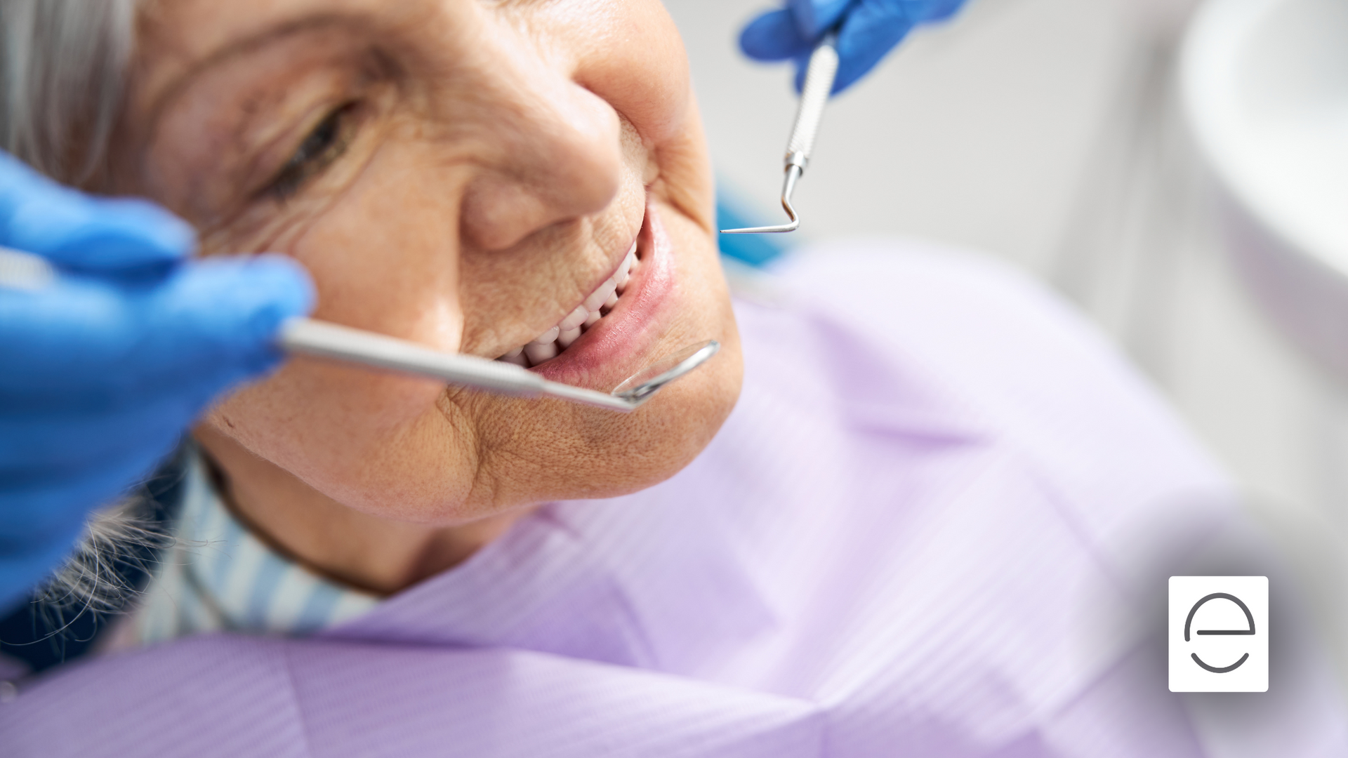 An elderly woman is having her teeth examined by a dentist.