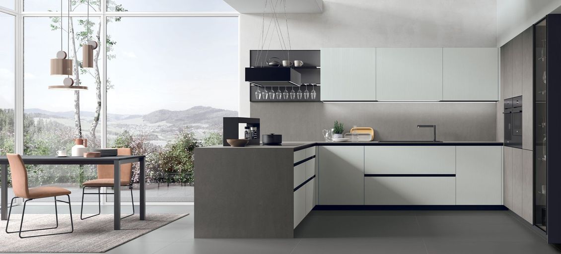 Una cucina con mobili bianchi, una grande isola, un tavolo e sedie.