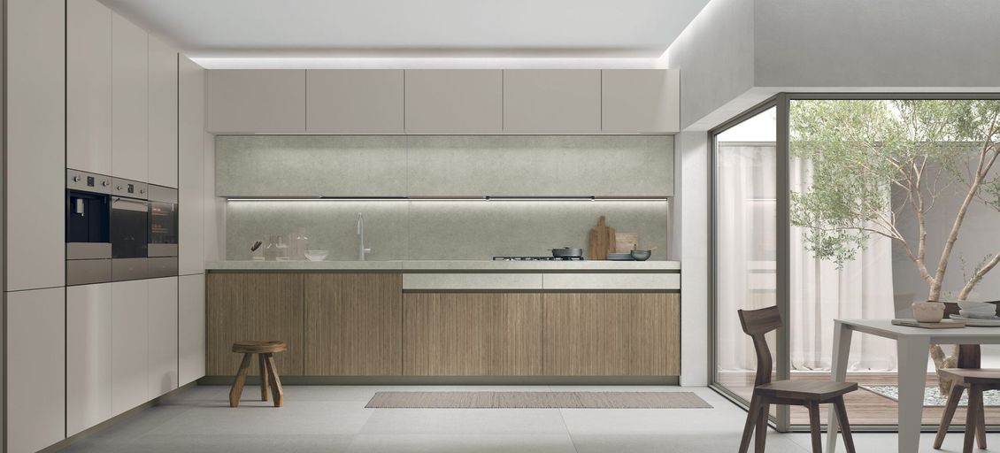 Una cucina con mobili in legno, tavolo e sedie.