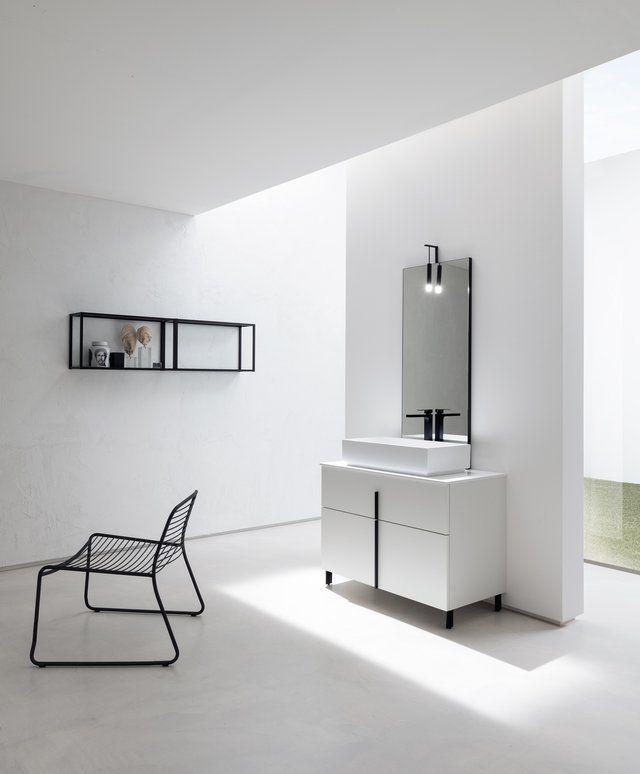 Un bagno con un lavandino uno specchio e una sedia