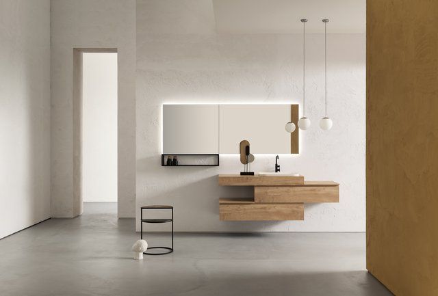 Un bagno con un lavandino e uno specchio sul muro.