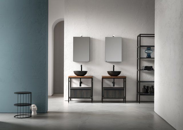 Un bagno con due lavandini, due specchi e una mensola.