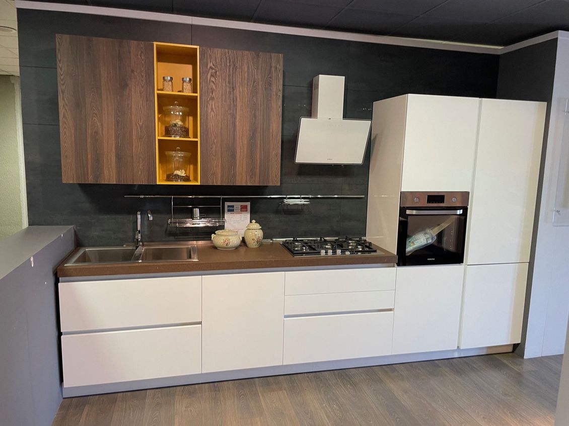 Una cucina con mobili bianchi e mobili in legno