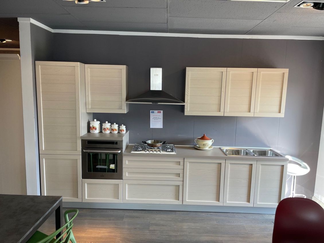 Una cucina con mobili bianchi e un piano cottura con forno